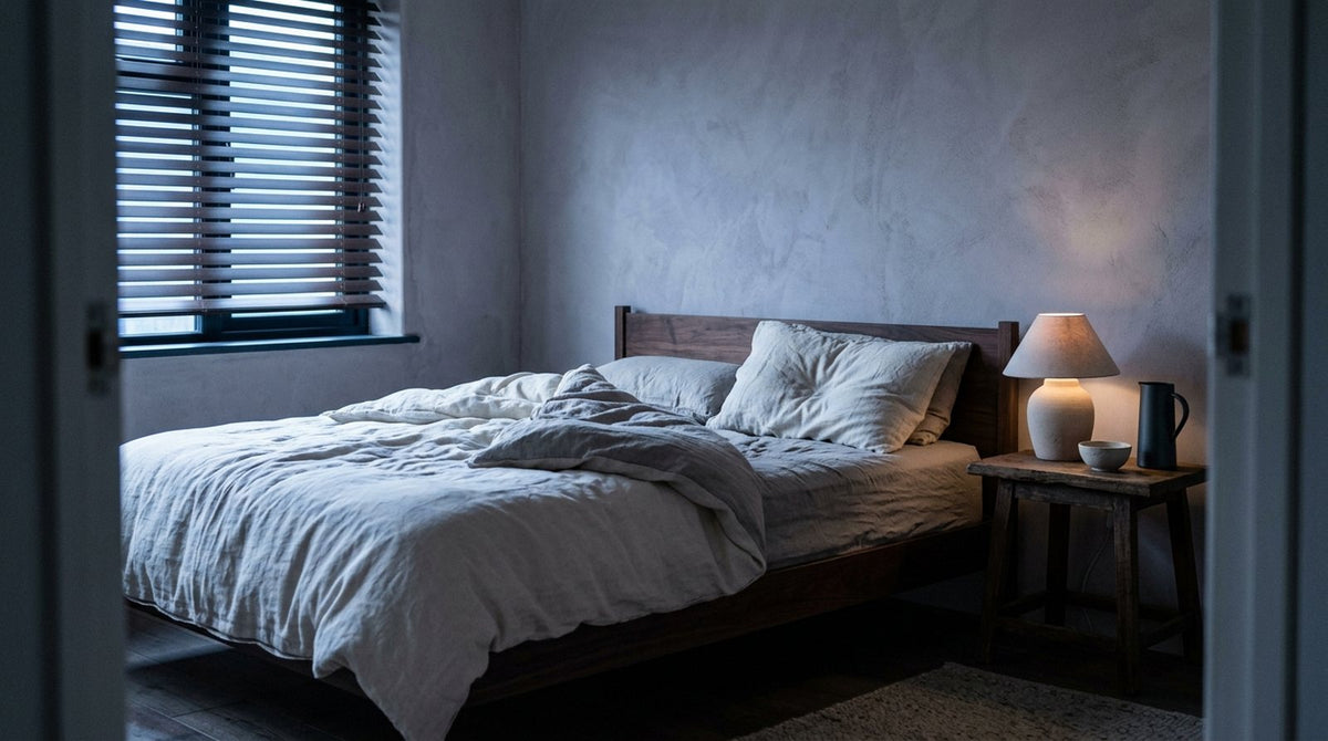 Dormitorio en tonos claros con una almohada cervical sobre la cama a primera hora de la mañana